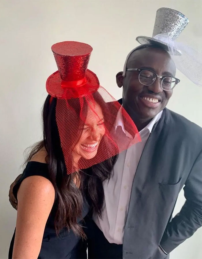 Two people smiling and wearing glittery red and silver hats with veils, illustrating Meghan Markle Vogue cover diva story. Two people smiling and wearing glittery red and silver hats with veils, illustrating Meghan Markle Vogue cover diva story.