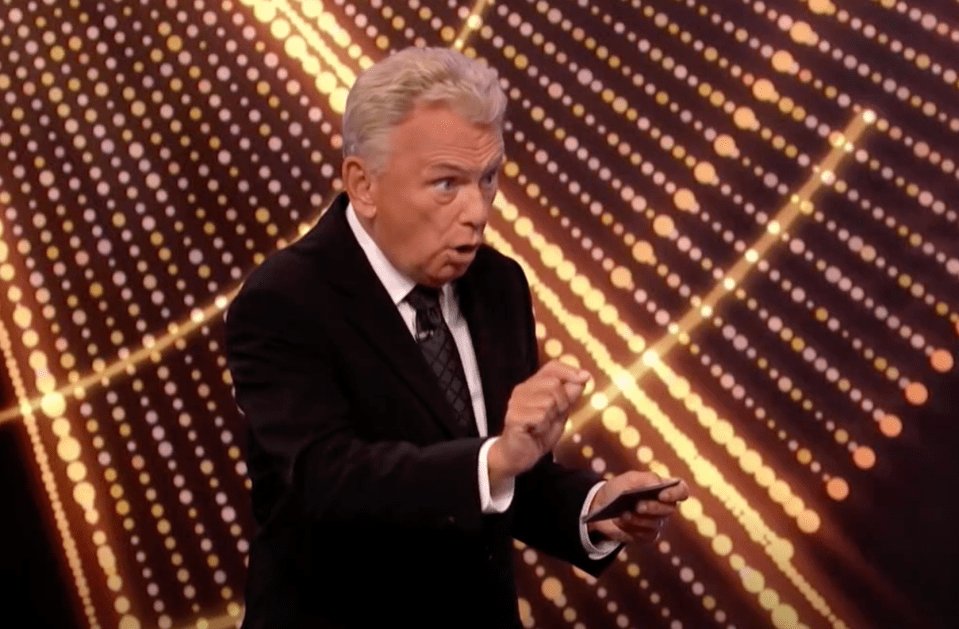 Pat Sajak hosting a game show, appearing surprised.