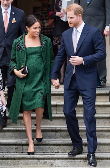 Meghan Markle and Prince Harry holding hands walking down stairs