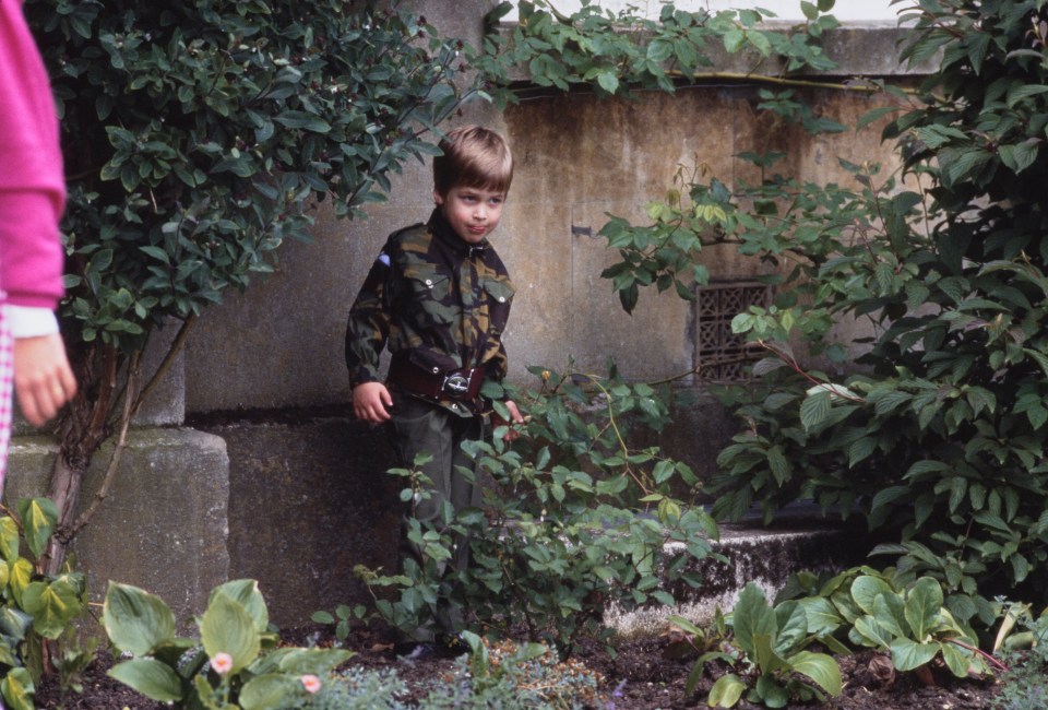 Photo of Prince William as a young boy in a camouflage uniform.
