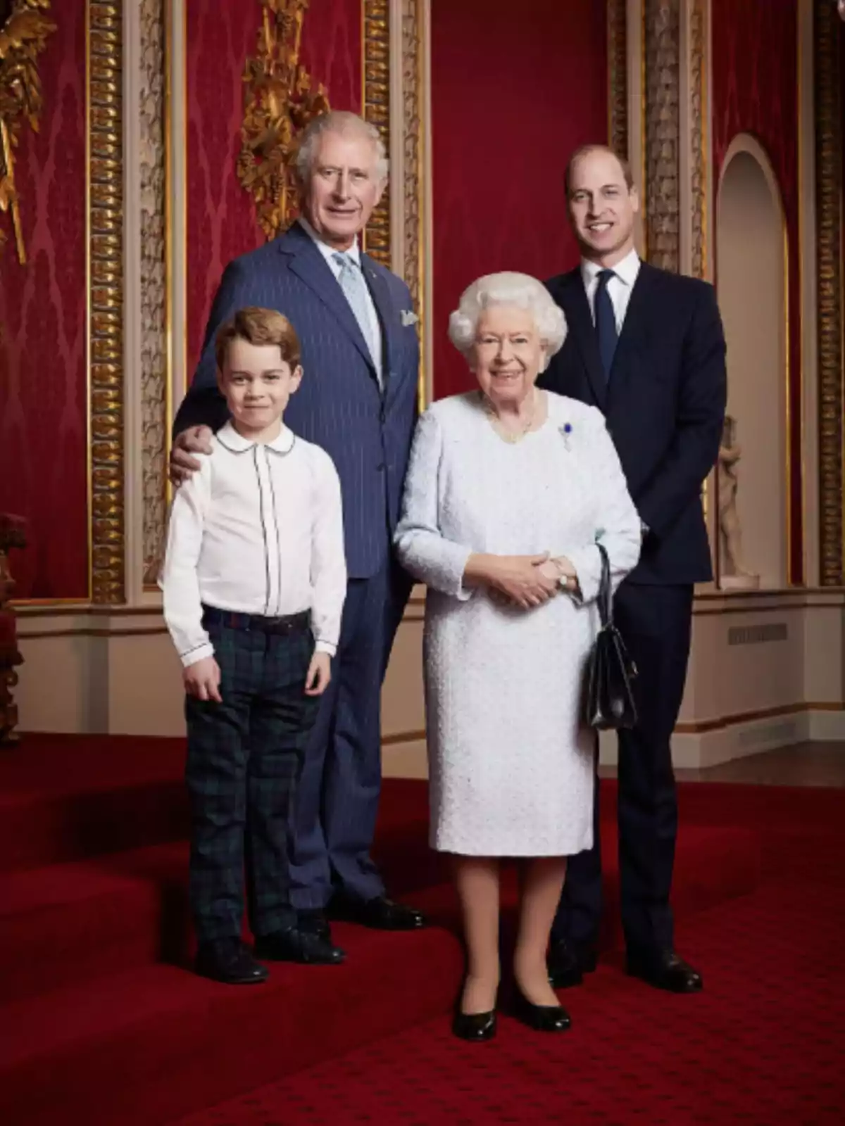 A group of people posing in an elegant room with red walls and golden details.