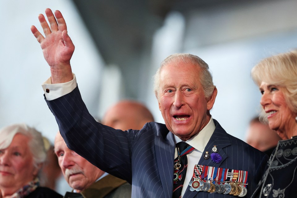 King Charles III waving at a VE Day 80th anniversary concert.
