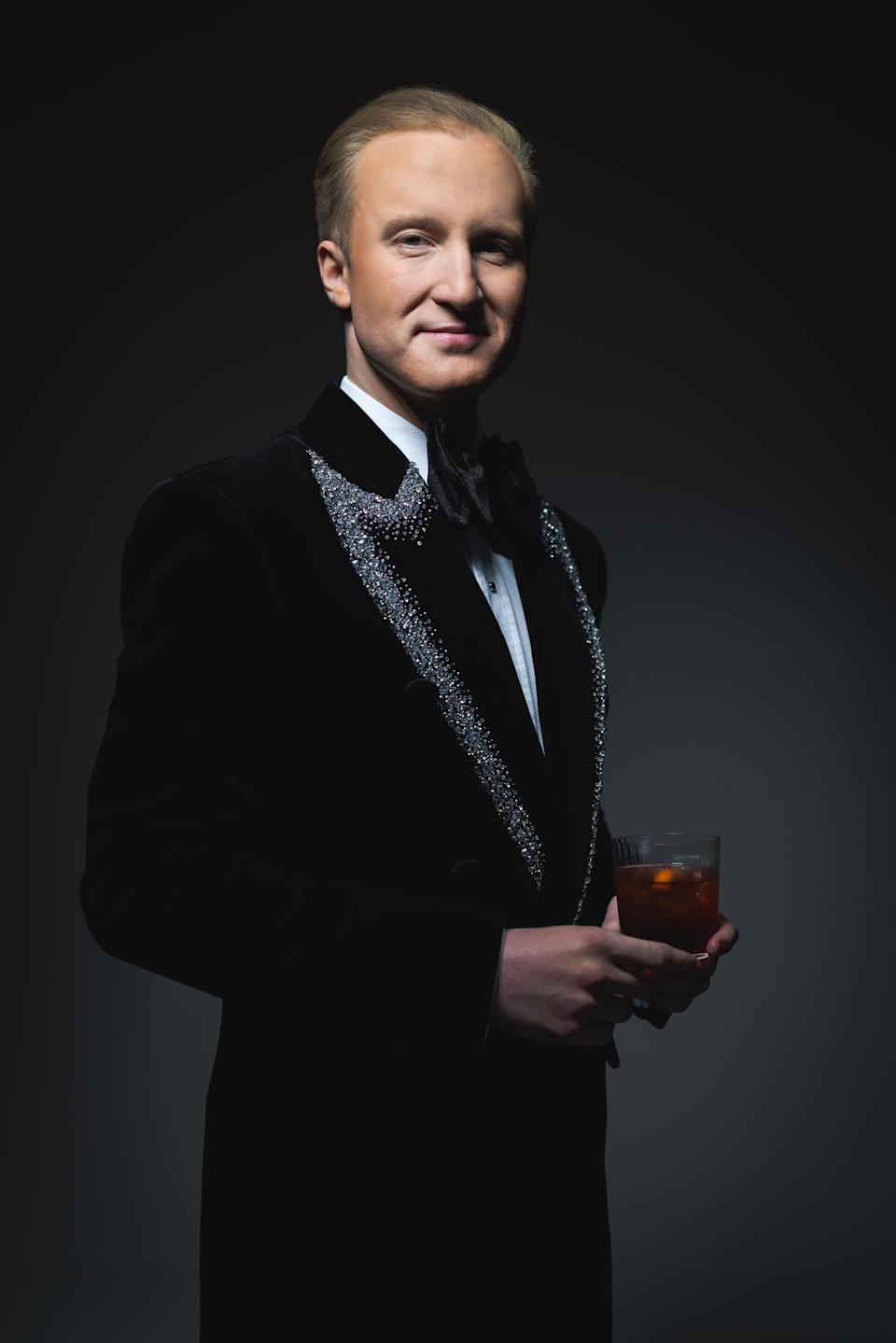 William Hanson wearing a black tuxedo holding a drink