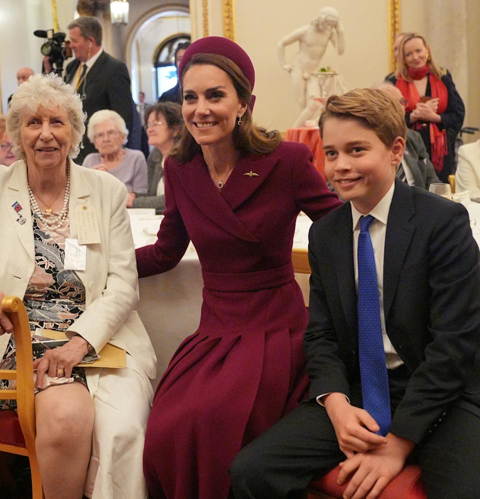 Prince George posing with his mom Kate Middleton and two women at a tea party.