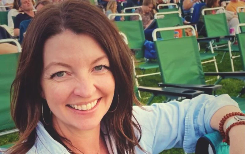 Woman smiling at outdoor event.