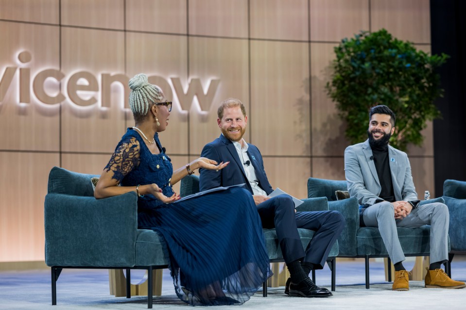 Prince Harry and two other panelists sitting on stage at a ServiceNow event.