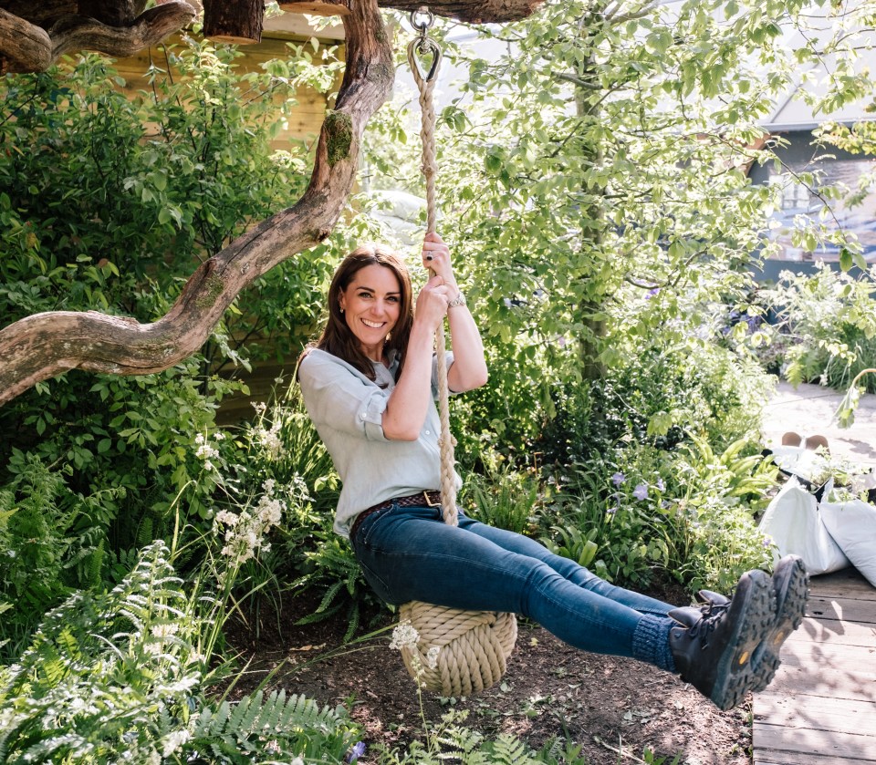 Catherine, Duchess of Cambridge, on a rope swing in a garden.