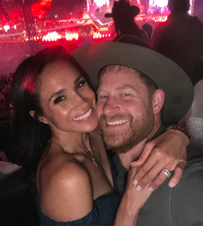 Prince Harry wearing cowboy hat with hidden symbols while sharing PDA with Meghan at a Beyoncé concert.