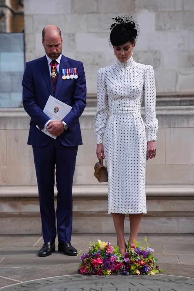 The Prince and Princess of Wales laying flowers at a memorial.