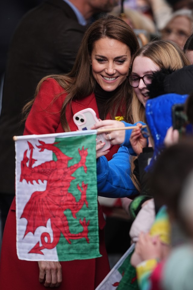 The Princess of Wales greets well-wishers and takes a selfie with them. A Welsh flag is visible.