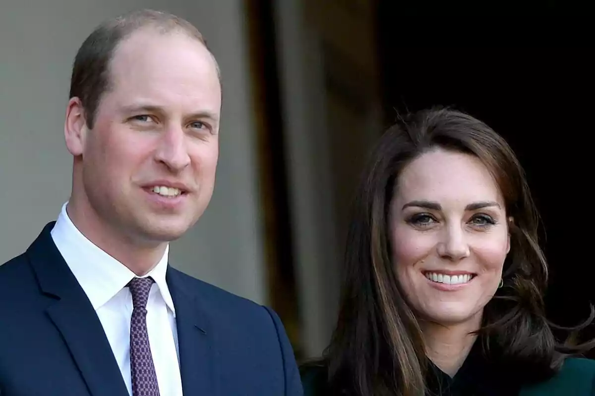 Prince William and Kate Middleton smiling while posing together at a formal event.