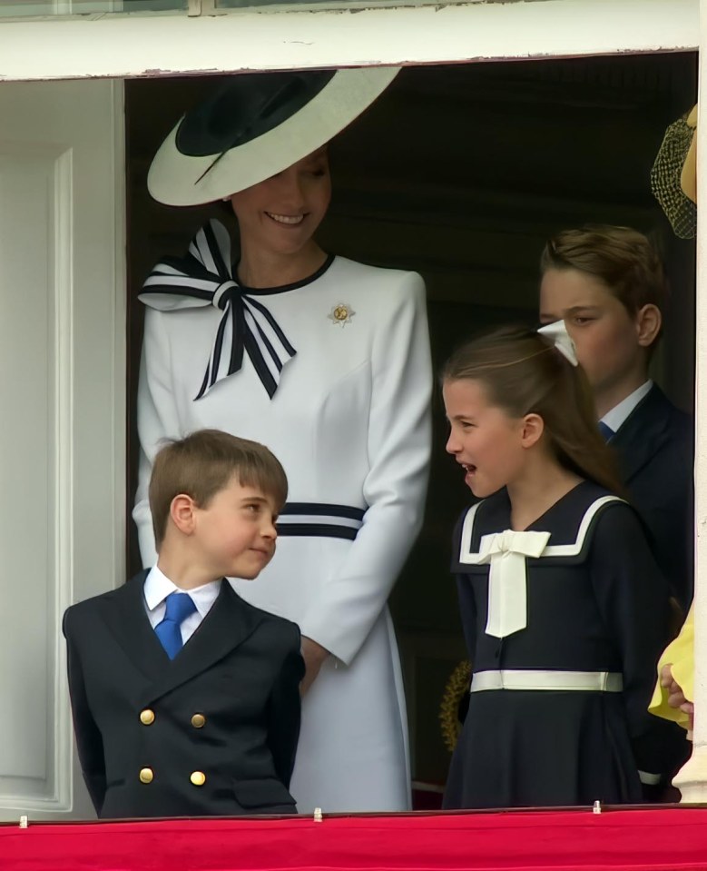 a woman in a white dress stands next to two children