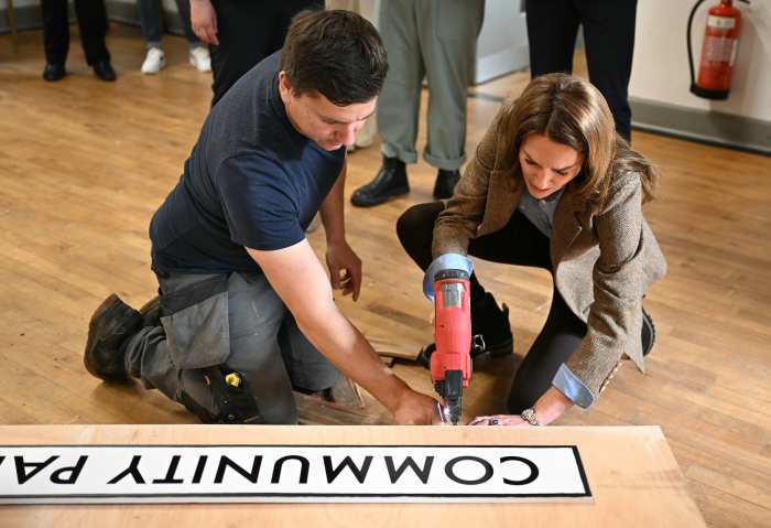 Catherine, Princess of Wales uses a nail gun as she helps to construct a sign for a Community Pantry, during a visit to Aros Hall, a local community hub on April 29, 2025 in Tobermory, Scotland. 