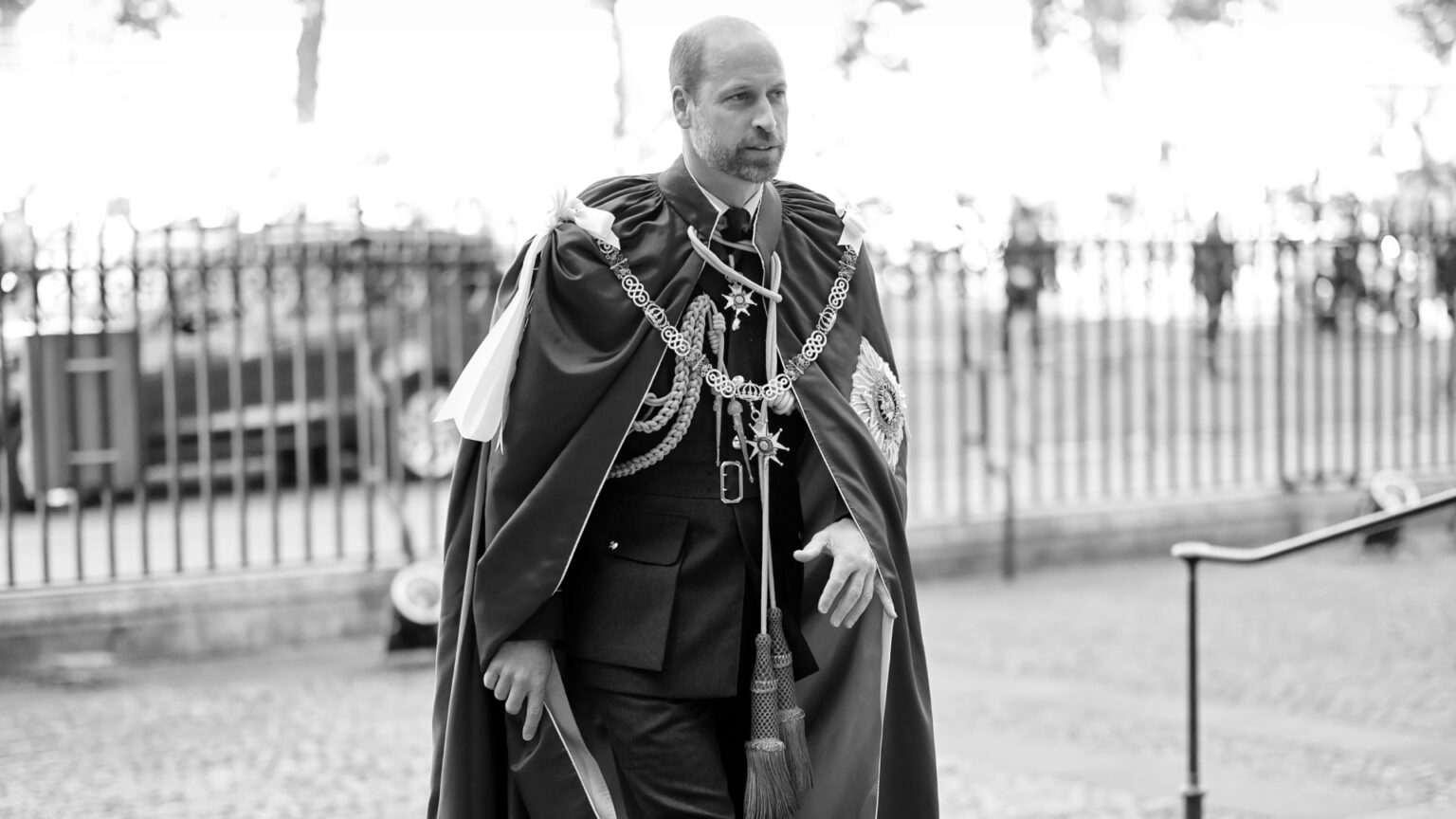 Prince William Is Planning This “Radical Departure” From King Charles and Queen Elizabeth When He Becomes King A black and white picture of Prince William wearing a robe with medals