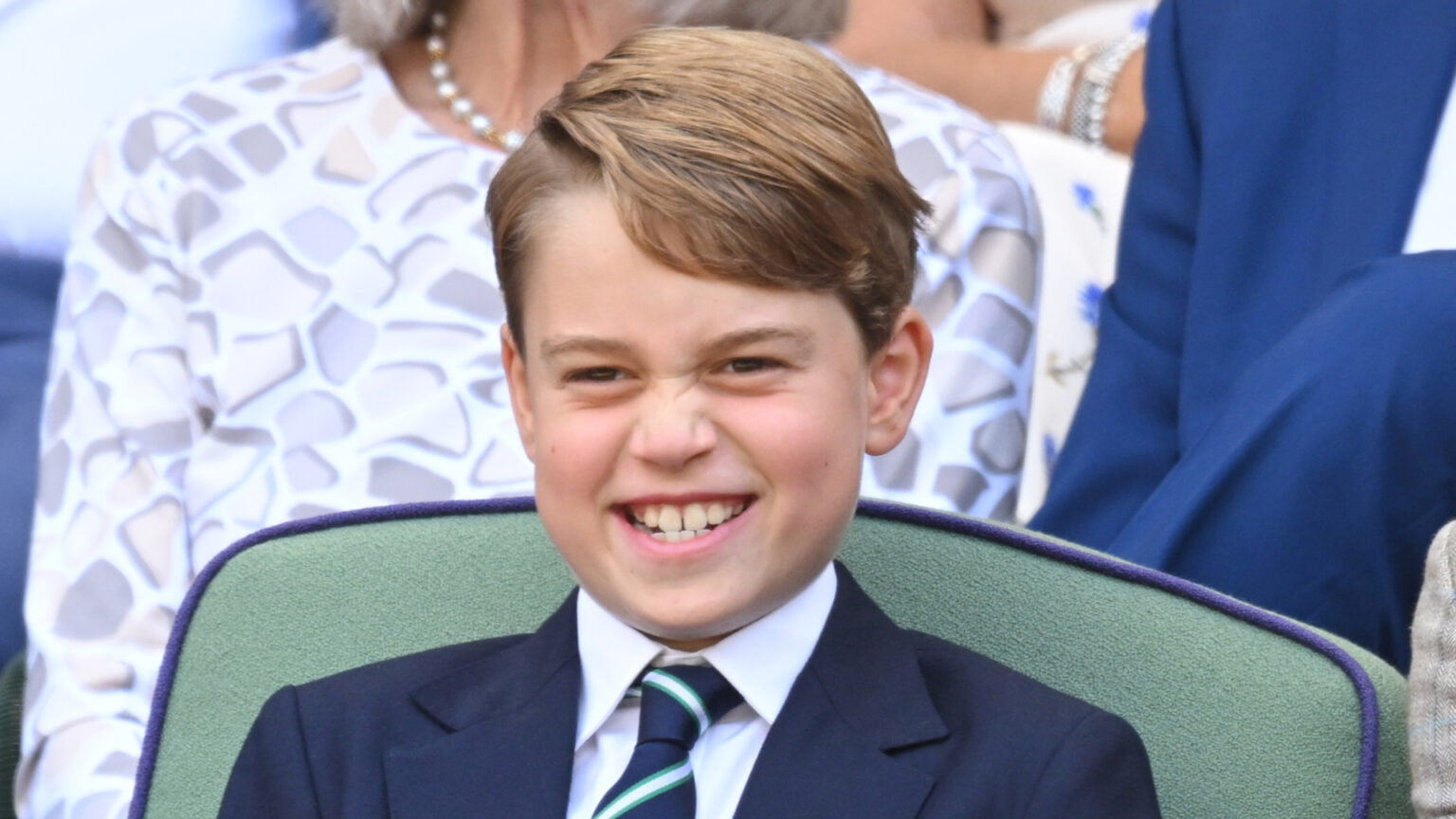 Royal Fans Have Found Prince George’s Royal Doppelganger Prince George grins while attending Wimbledon and wearing a navy suit with a white shirt and striped tie
