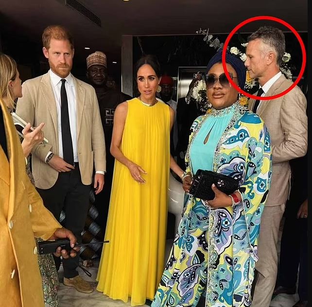 a man in a suit is standing next to a woman in a yellow dress