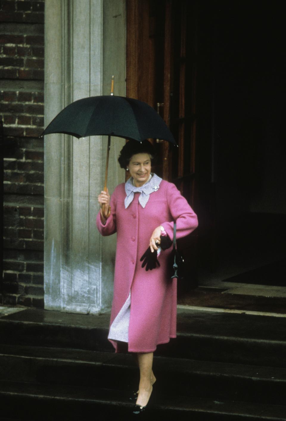 Queen Elizabeth II wears a pink coat and holds a black umbrella leaving the Lindo Wing after Prince William's birth, and the Royal Family poses for photos at William's christening