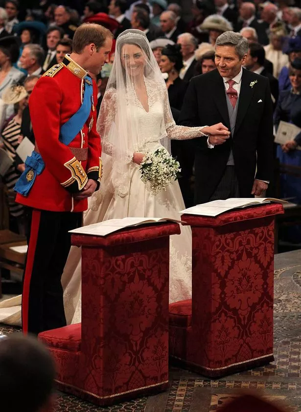 Prince William speaks to his bride Catherine Middleton as she holds the hand of her father Michael Middleton on April 29, 2011 in London, England. 