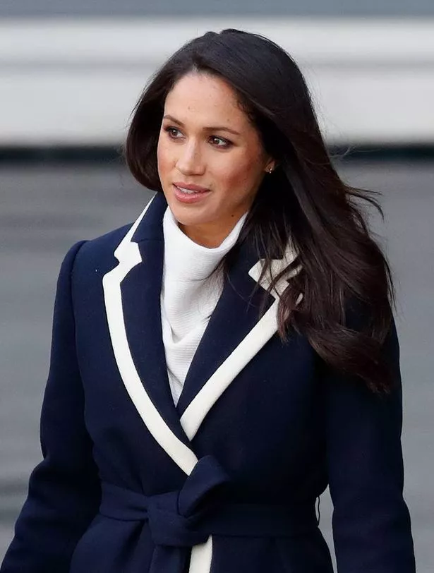 Meghan Markle wearing a navy and cream outfit while out walking 