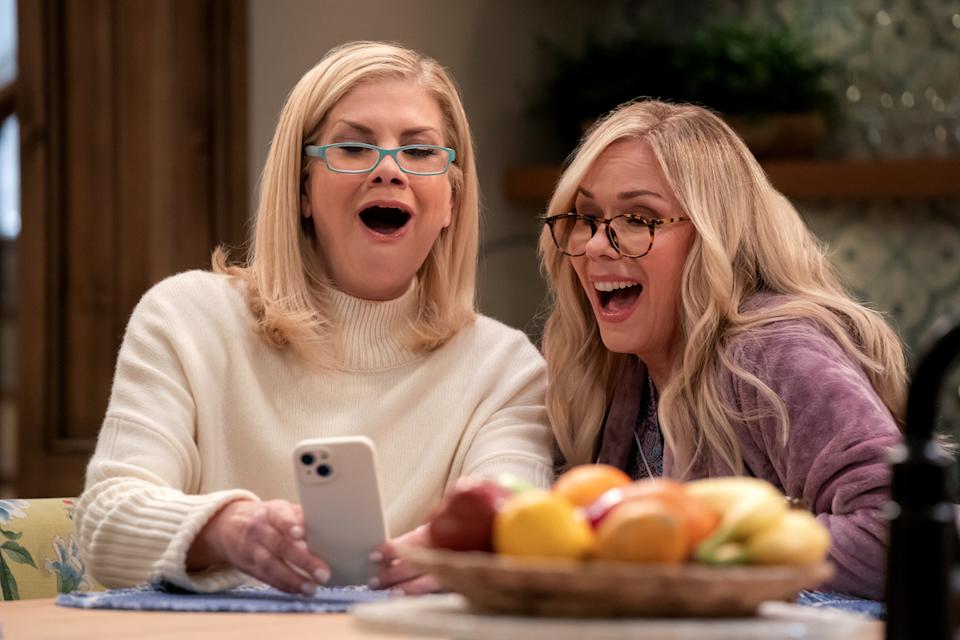 Johnston and Leanne Morgan laugh while looking at Johnston's cellphone in a scene from the upcoming Netflix sitcom Leanne.