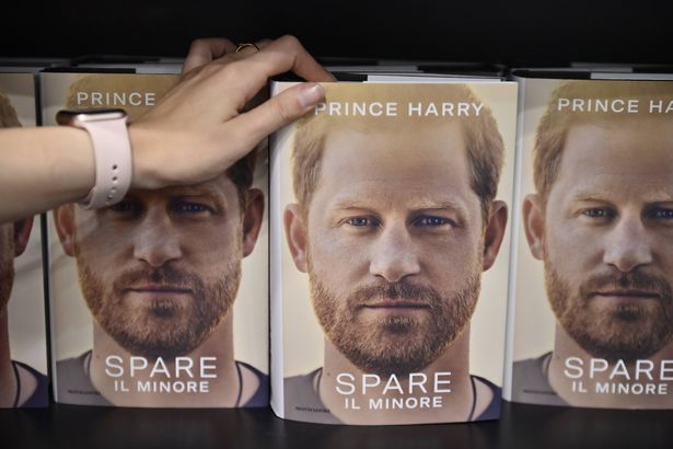 Hands holds the Prince Harry book Spare