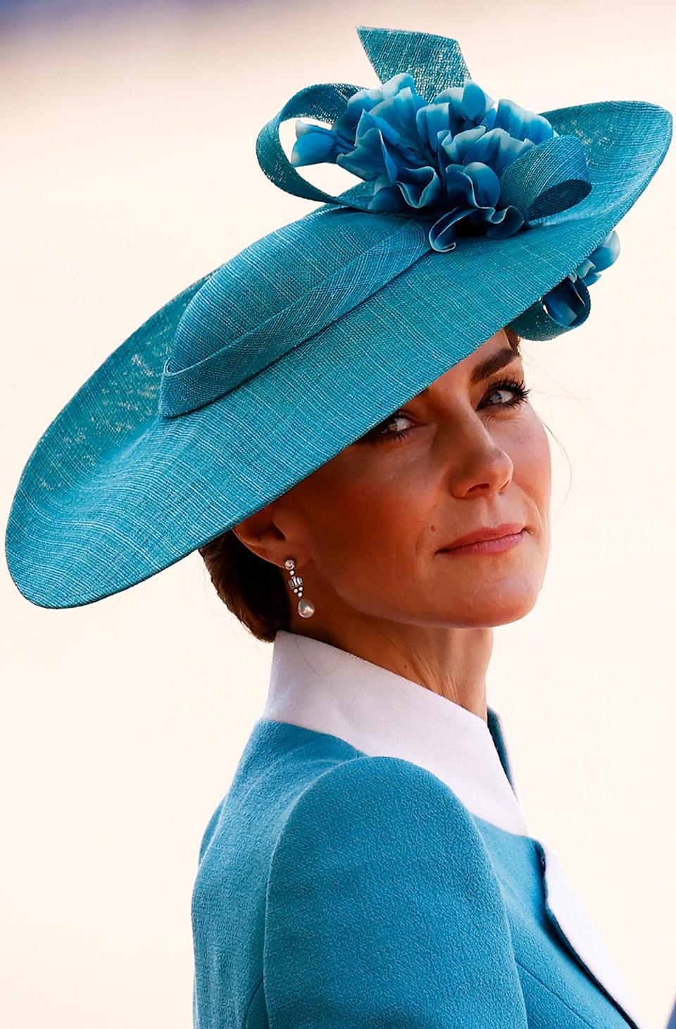 A close-up of Kate Middleton in a blue and white suit with a matching hat.