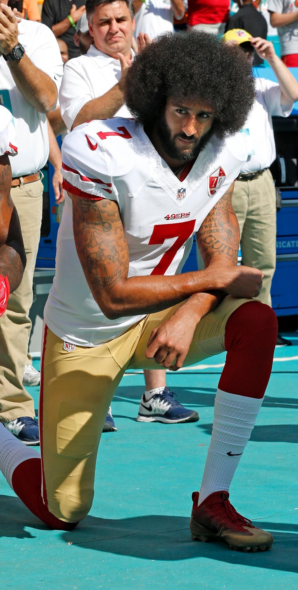 Colin Kaepernick kneeling on a football field during the national anthem