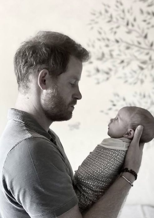 Prince Harry holding a swaddled Princess Lilibet