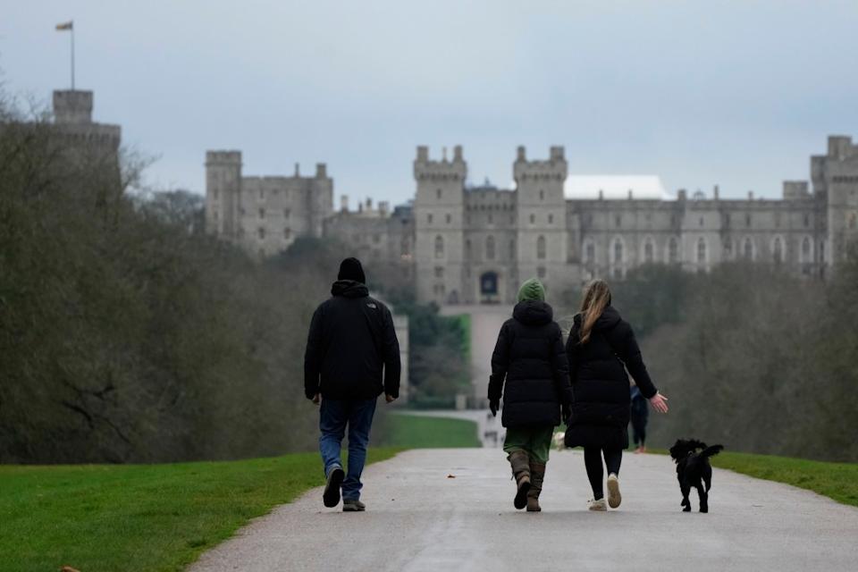 People walk their dogs on the Long Walk at Windsor, England, on Christmas Day, Saturday, Dec. 25, 2021. Britain’s Queen Elizabeth II has stayed at Windsor Castle instead of spending Christmas at her Sandringham estate due to the ongoing COVID-19 pandemic. (AP Photo/Alastair Grant)