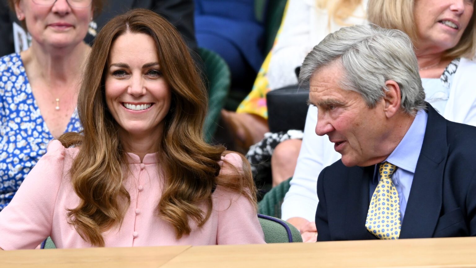 How Kate Middleton’s Dad Left Her Mortified at Wimbledon Kate Middleton wears a pink shirt dress and has long brown wavy hair attending Wimbledon with her dad Michael Middleton