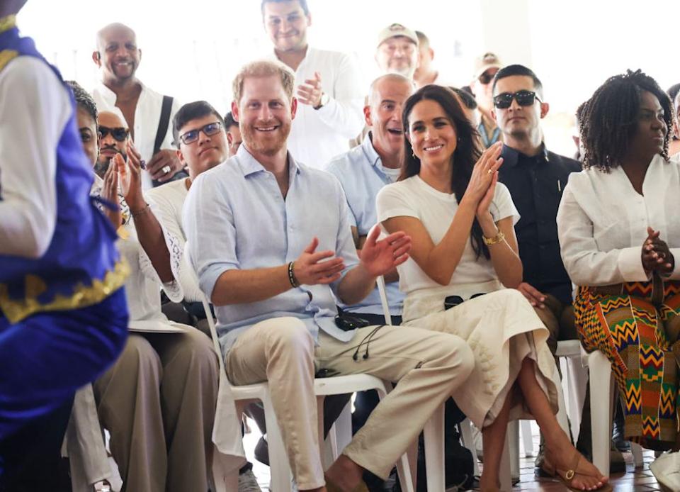 Harry and Meghan clapping in a crowd