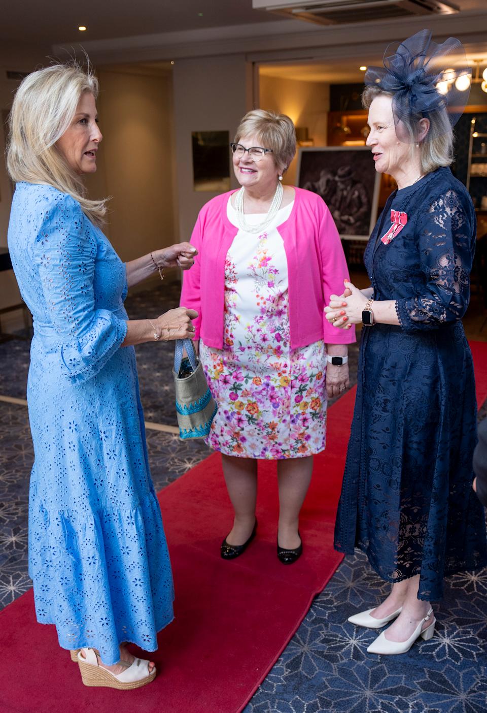 Duchess Sophie wearing a blue dress talking to two women