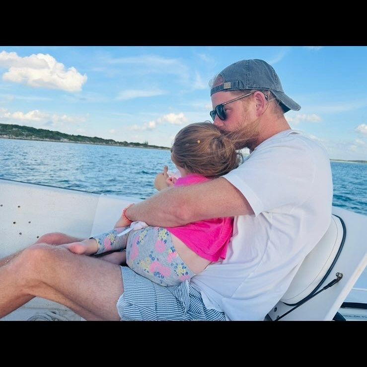 Prince Harry cuddling Lilibet on a boat