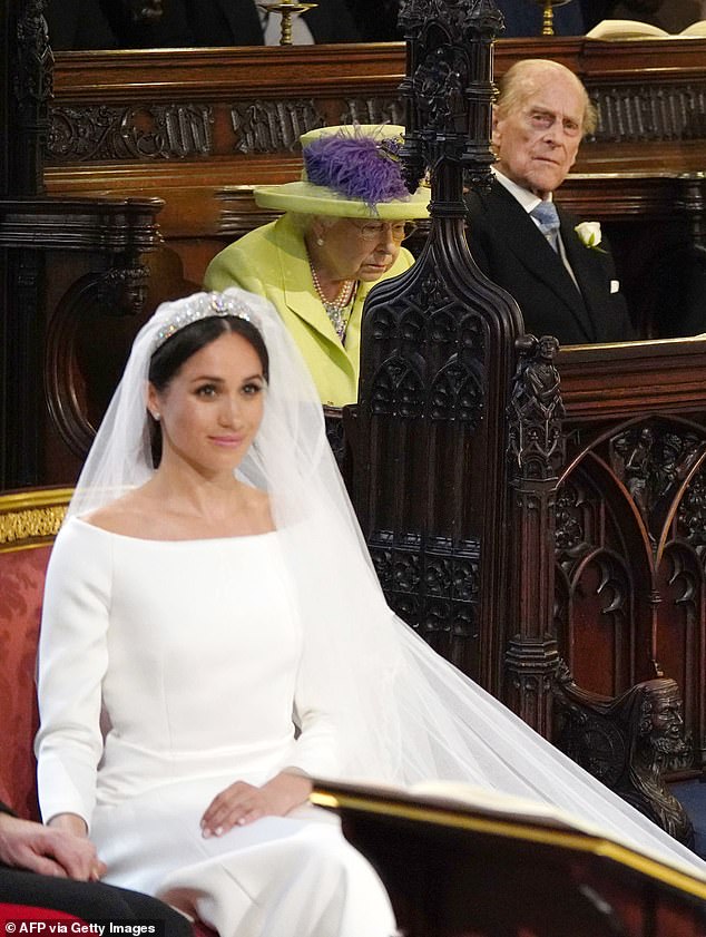 Meghan is pictured on her wedding day to Harry on May 19, 2018, as Prince Philip and the late Queen look on