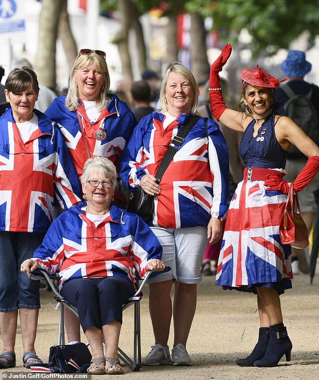 A group of women dressed in Union Jacks take their place on the Mall hoping to see the royals