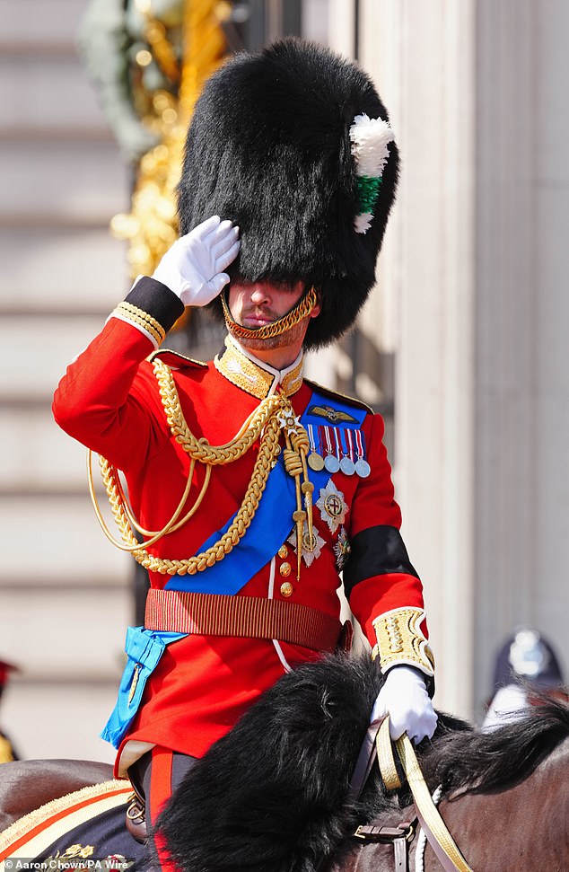 A barely recognisable Prince William salutes during the Trooping the Colour ceremony on London on Saturday, bearing a black armband in remembrance of all those who died during the Air India crash on Thursday, which took the lives of 52 Britons