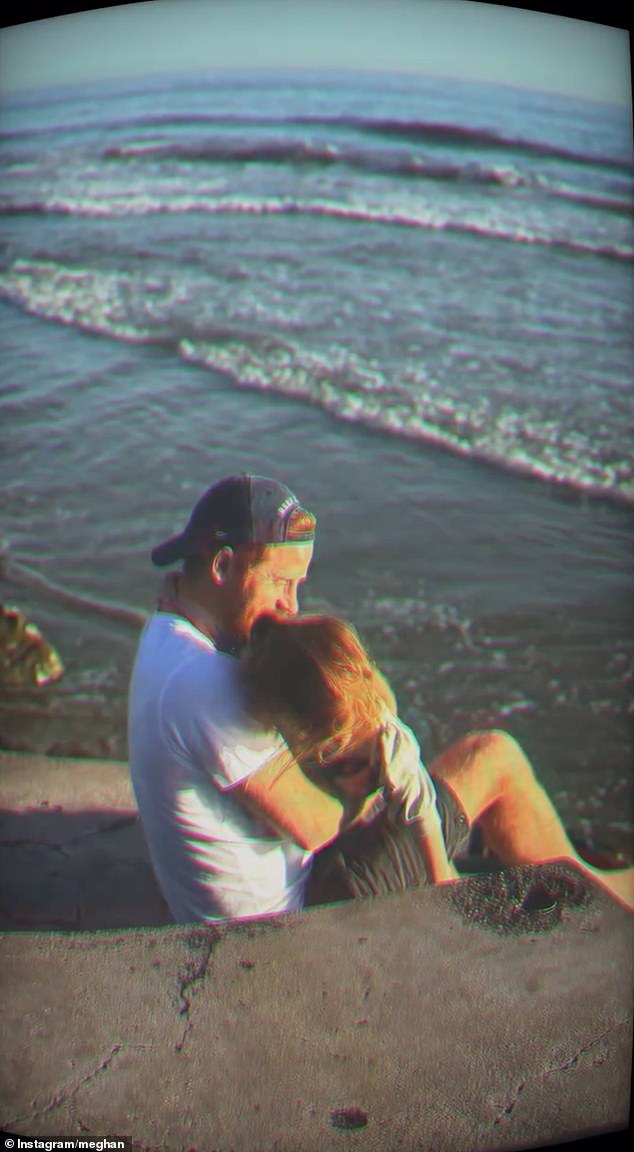 This pic of Harry shows him cuddling with Lilibet as they sit on a beach looking out at the ocean