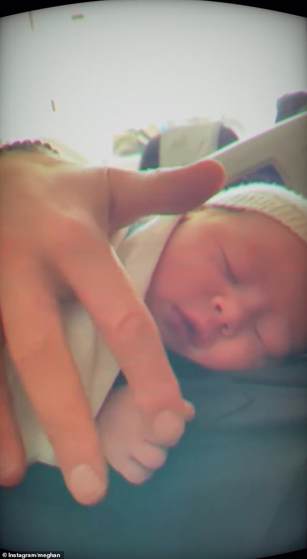 Harry is seen cradling one his newly born children on his chest