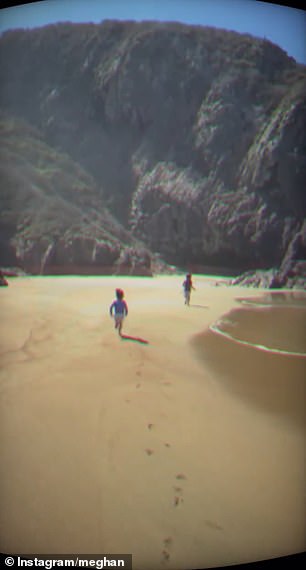 Harry and Meghan's children Lilibet and Archie are seen running on a breach in front of a mesmerising mountain side