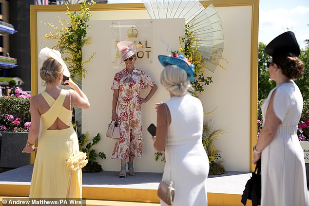 A racegoer poses for a photograph on day two of Royal Ascot at Ascot Racecourse today