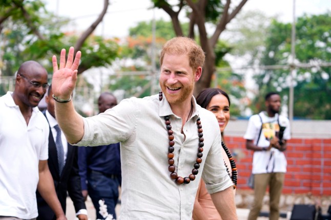Prince Harry gestures as he and Meghan visit children at the Lights Academy in Abuja, Nigeria, Friday, May 10, 2024. Prince Harry and his wife Meghan have arrived in Nigeria to champion the Invictus Games, which he founded to aid the rehabilitation of wounded and sick servicemembers and veterans. (AP Photo/Sunday Alamba)