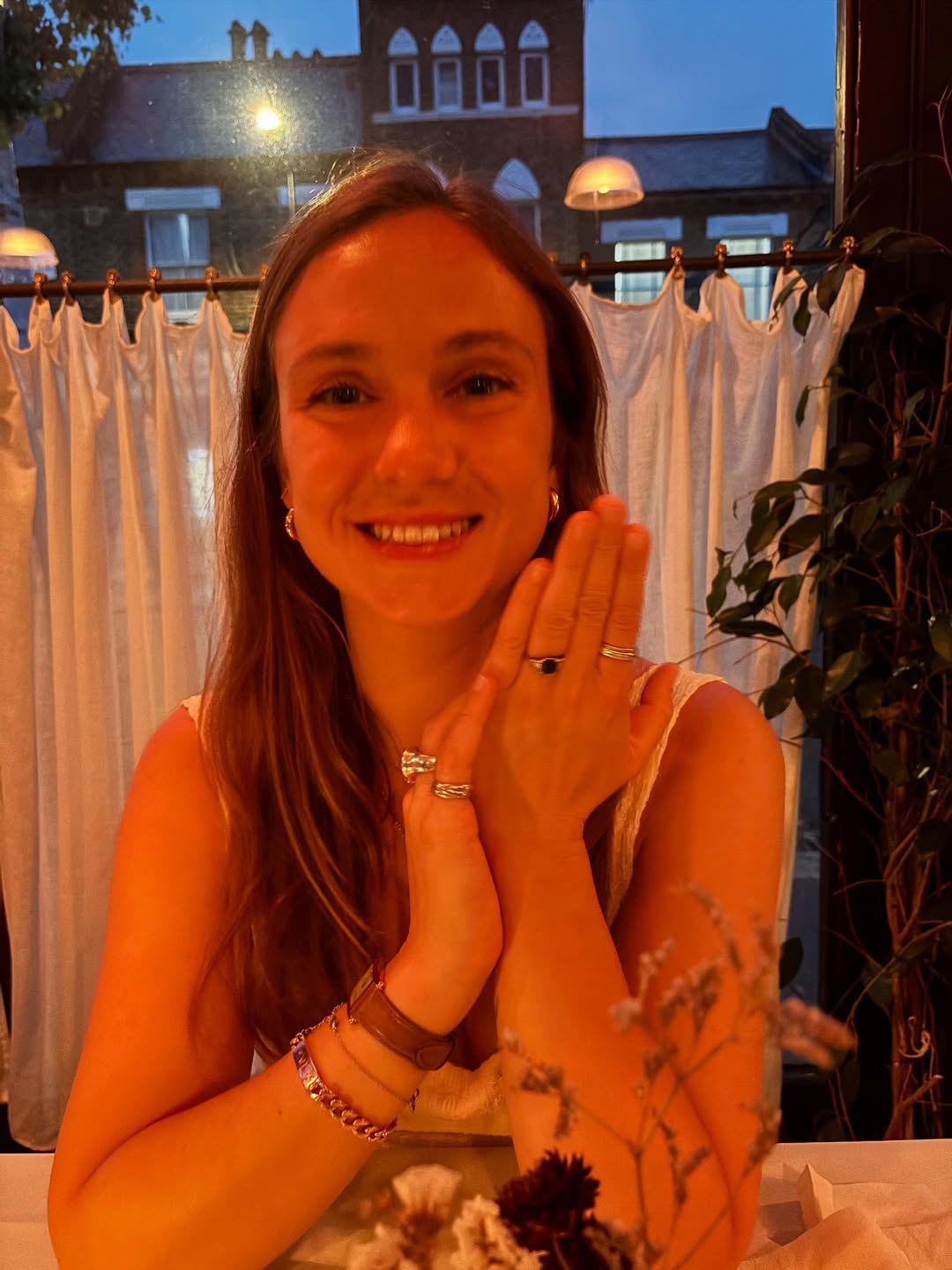 Lady Marina Windsor sitting at a restaurant showing her engagement ring