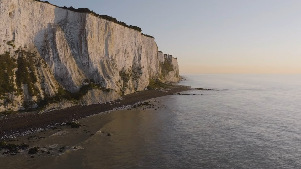 Aerial view of white cliffs meeting the ocean.