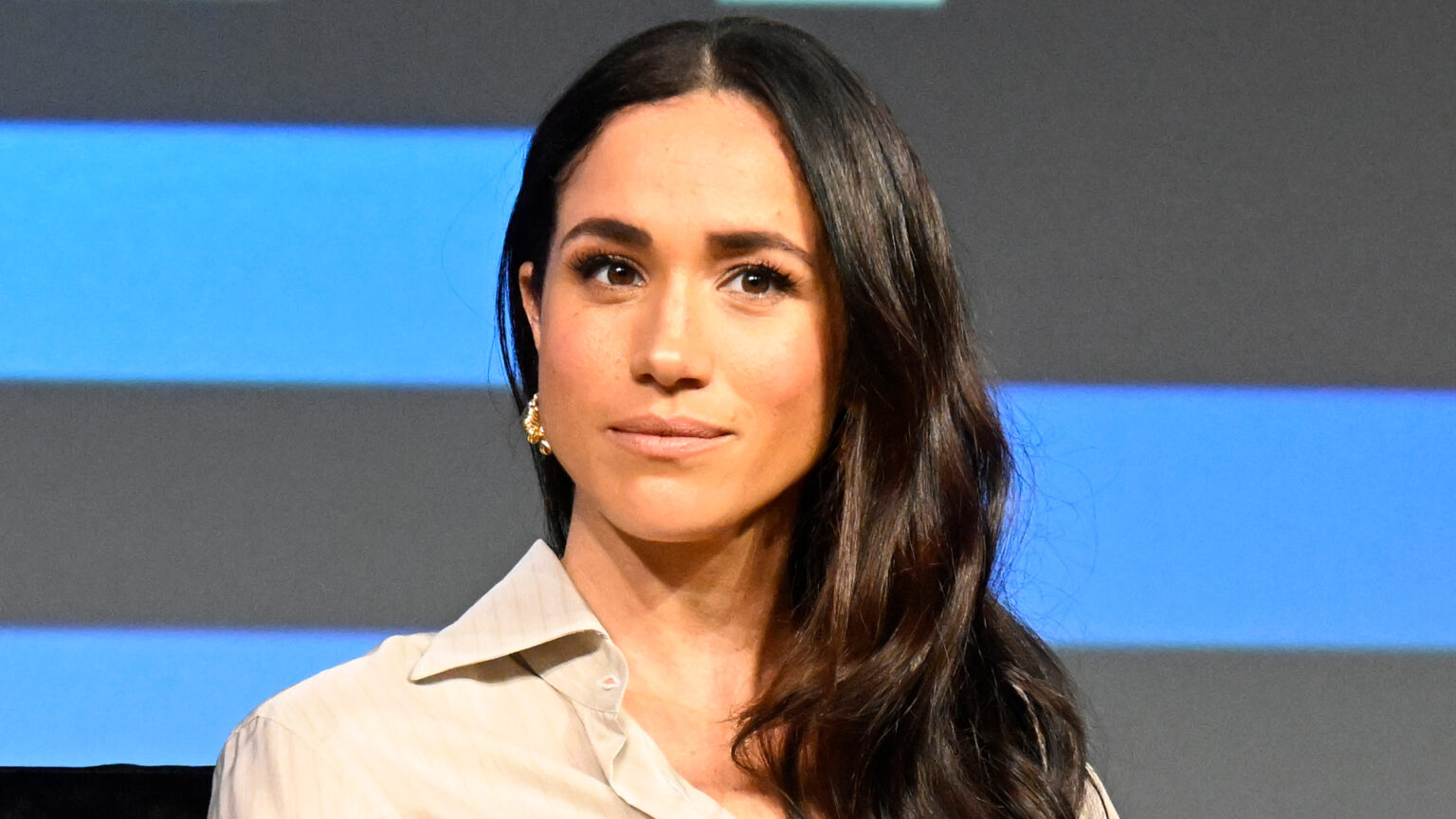 Meghan Markle Wants Archie and Lilibet to Recognize Privilege Meghan Markle wears a cream shirt and has long dark brown hair