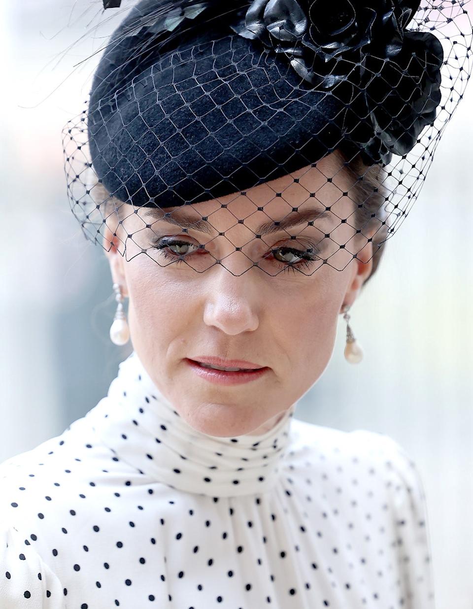 A close-up of Kate Middleton wearing a polka dot dress and a black fascinator.