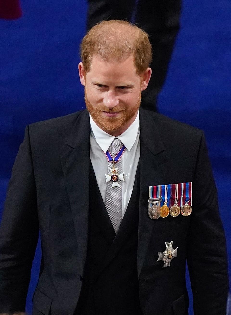 Prince Harry wearing a dark suit with medals