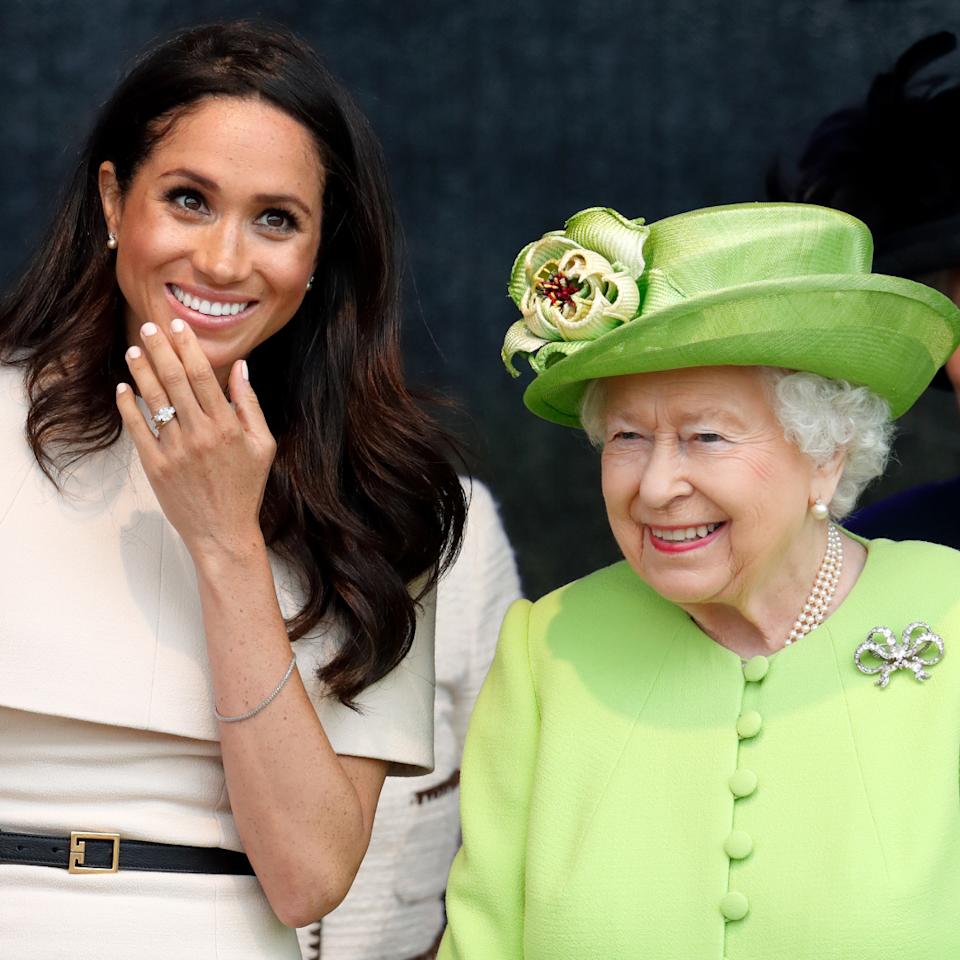  Meghan Markle wears a cream dress and attends a joint engagement with Queen Elizabeth, who wears a bright green coat, on June 14, 2018. 