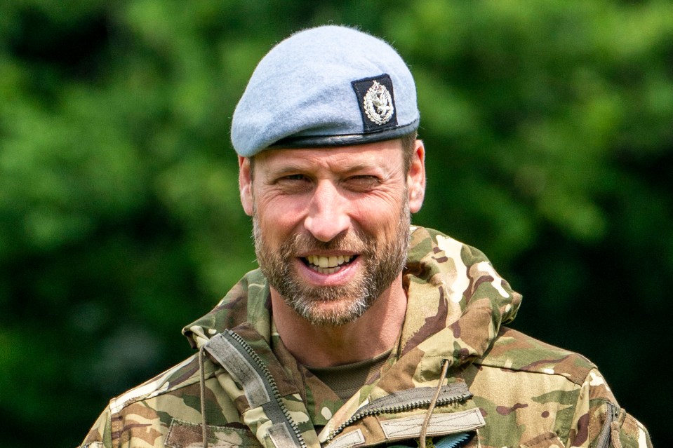 Prince William in military uniform smiling.