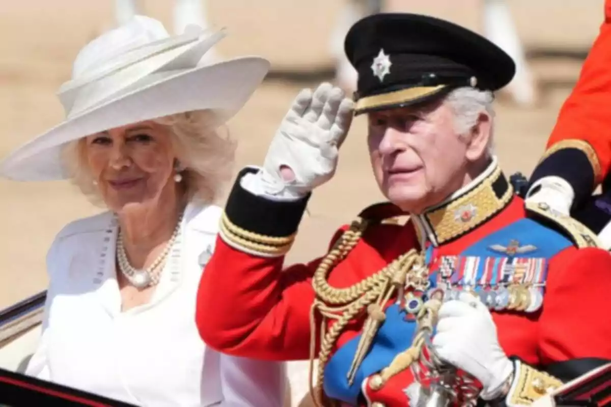 Elegantly dressed couple in a carriage during an official event; he is wearing a military uniform and she a white hat.