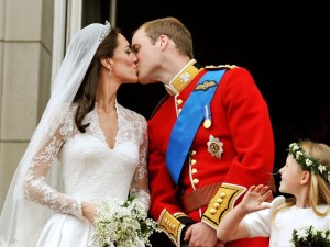 Prince William and his wife Kate Middleton, who has been given the title of The Duchess of Cambridge, kiss on the balcony of Buckingham Palace, London, following their wedding at Westminster Abbey. PRESS ASSOCIATION Photo. Picture date: Friday April 29, 2011. See PA story WEDDING Lead. Photo credit should read: John Stillwell/PA Wire